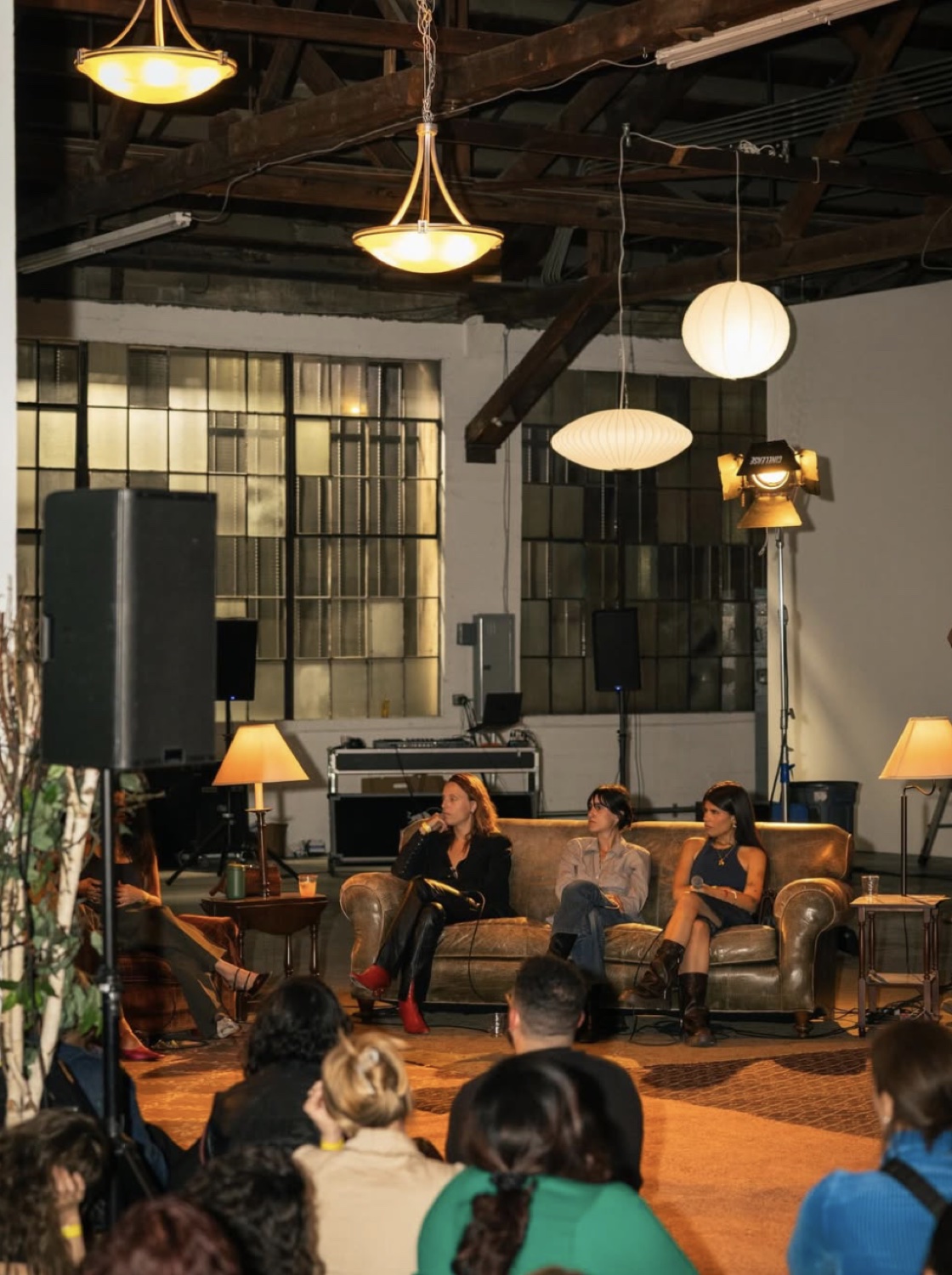 the panel — three women, one couch, a packed room